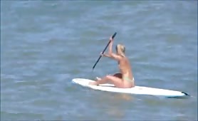 Thong bikini babe doing stand up paddling